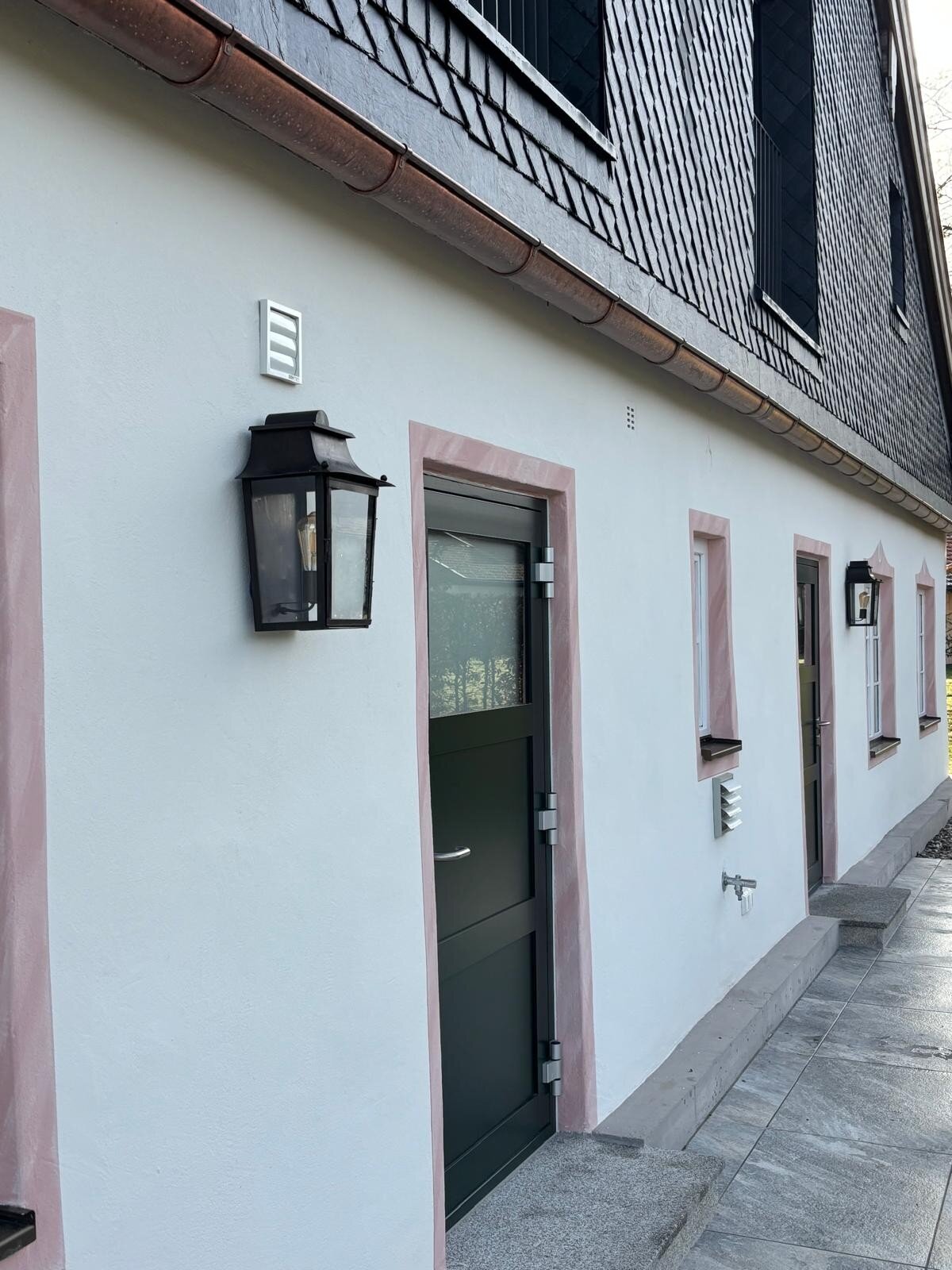 historische Wandleuchte aus Messing an einem sch&ouml;nen Landhaus mit L&uuml;ftelmalerei. LumArt at its best.