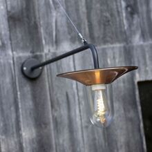 Mit ihrem geraden Wandarm und der Drahtseilstabilisierung verbindet die Cooper Leuchte rustikale Eleganz mit moderner Funktionalität. Das Lampenglas ist zylindrisch und leitet das Licht nach unten.