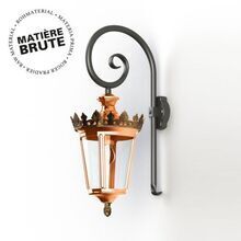 Die Wandleuchte Louvre Modell 2 vereint zeitloses Design mit natürlichem Charme. Hergestellt aus unbehandeltem Kupfer, ermöglicht sie die natürliche Entwicklung einer authentischen Patina. Mit kunstvoller goldener Krone, klarem, rundem Glas und geschwungenem Wandhalter im Aussehen eines Bischofstabs fügt sie sich perfekt in stilvolle Außenbereiche ein. Ideal für Fassaden, Eingänge und Terrassen – diese wetterfeste Leuchte setzt elegante Akzente.