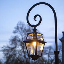 Die Place des Vosges 2 Nr. 9 ist eine exklusive Gartenleuchte von Roger Pradier. Ihre Laterne hängt an einer geschwungenen Bischofsstab-Befestigung und verleiht Terrassen und Mauern eine elegante Lichtquelle.