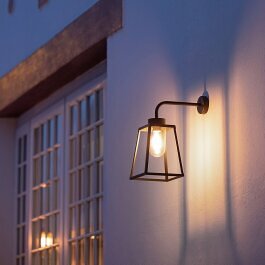 moderne Wandleuchte von Roger Pradier. An klassischer Fassade. Licht ist nach unten und seitlich gerichtet.