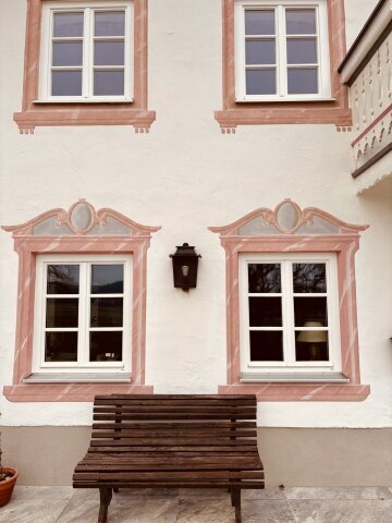 Messing antique fügt sich harmonisch in natürliche Materialien einer Fassade ein.