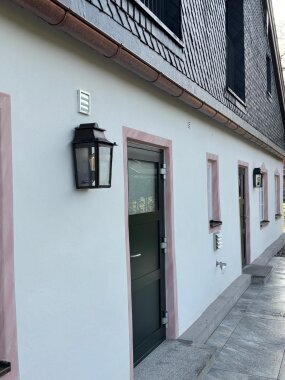 historische Wandleuchte aus Messing an einem schönen Landhaus mit Lüftelmalerei. LumArt at its best.