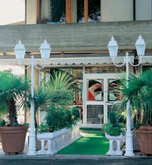 Aussenleuchten mit 2 Lampenauslegern, Weiß, viereckige Lampen, gebogene Lampenarme. Vor einem italienischen Restaurant.