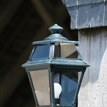 Roger Pradier kombiniert in dieser Außenleuchte französisches Design mit der natürlichen Eleganz einer Grünspan-Patina. Die klare Glaseinfassung und der kurze Wandarm unterstreichen ihre stilvolle Optik.