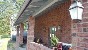 mediterrane Wandleuchten für aussen. Viereckige Form an schlichtem Lampenarm. An einem Landhaus mit Ziegelmauer.