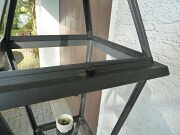 Außenleuchte schmaler Mast mit 4-eckiger Lampe. Vor Gartenmauer. H. 210cm. Alu, grau.