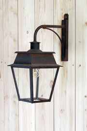 Historische, individuelle Außenleuchten von LumArt.<br />
Diese Wandleuchte ist viereckig und ist unter einem schlichten Wandarm mit stabilisierungsstrebe montiert. Die Außenleuchte hat die LED Birne Edison Kolben im Oberteil eingebaut. Die Lampenfassung ist E27. Vier Lampengläser schützen den Innenraum der antiken Wandlampe. Die Oberfläche ist in einem antiken Farbton gestaltet. Das Material besteht aus Messing oder Zink.