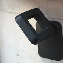schwarze Außenleuchte modern an heller Naturstein Hauswand. drehbar, LED 30W 4000°K , IP65, IK09, klasse 1, 3.06 kg H: 259 mm B: 226 mm T: 271 mm