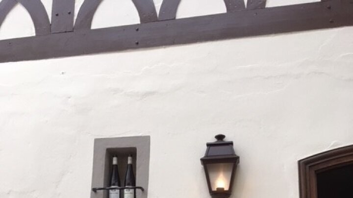 braune Wandleuchteaußen an Hauswand von Weingut in Deutschland. Montiert neben Fenster und Haustür.