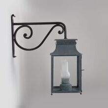 Handgefertigte Außenwandleuchte mit historischer Optik
Die Pétrole Nr. 117 ist eine kunstvoll gestaltete historische Wandlaterne, inspiriert von 19. Jahrhundert Kerosinlampen. Viereckiges Design. Jugendstil-Wandarm. Laterne hängt unter dem Wandarm.