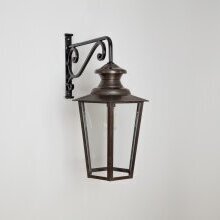 „Kombination aus Retro-Leuchte und moderner Architektur – Vaucresson Nr. 1121 an weißem Putz“. 45° Betrachtungswinkel. Historische Wandleuchte unterhalb des gebogenem Wandarms montiert. Messing antique patiniert mit Klarglasscheiben.