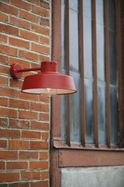 Gefertigt aus wetterfestem Aluminium in der Farbe Tomatenrot, ist die Faktory Nr. 1 die ideale Wahl für Außenbereiche wie Freisitze und Gartenmauern. Das Design ist rund, die Verglasung in Zylinderform.