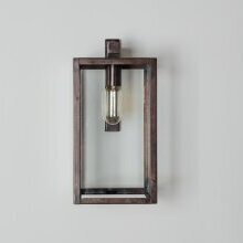 Diese Aufnahme betont den Kontrast zwischen moderner Architektur und klassischer Leuchtenform. Die Leuchte wirkt leicht und elegant, ohne dominant zu erscheinen. Der gealterte Messingrahmen setzt einen warmen Akzent auf der schlichten Fläche.