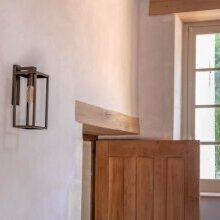Materialmix aus Tradition und Moderne – ein echter Blickfang. Rechteckiges Lampengehäuse aus antikem Messing Finish unterhalb eines schwarzen Leuchtenarms in Form eines L.