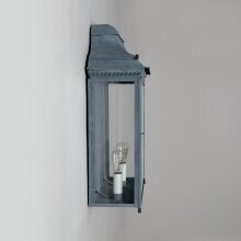 Die flache Bauweise ragt dezent aus der Wand, während das Licht durch die Glaselemente sanft nach vorne abstrahlt. Das rechteckige Gehäuse ist aus gealtertem Zink.