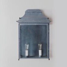 Großformatige Wandleuchte mit stilisiertem Fries und gealtertem Zink-Finish – elegant positioniert an einem klassischen Wandbereich.