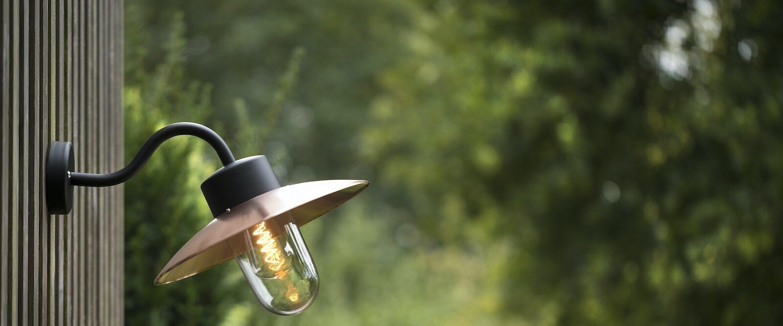 Klassische Außenwandleuchte aus Messing erhellt stilvoll den Eingangsbereich einer Villa.